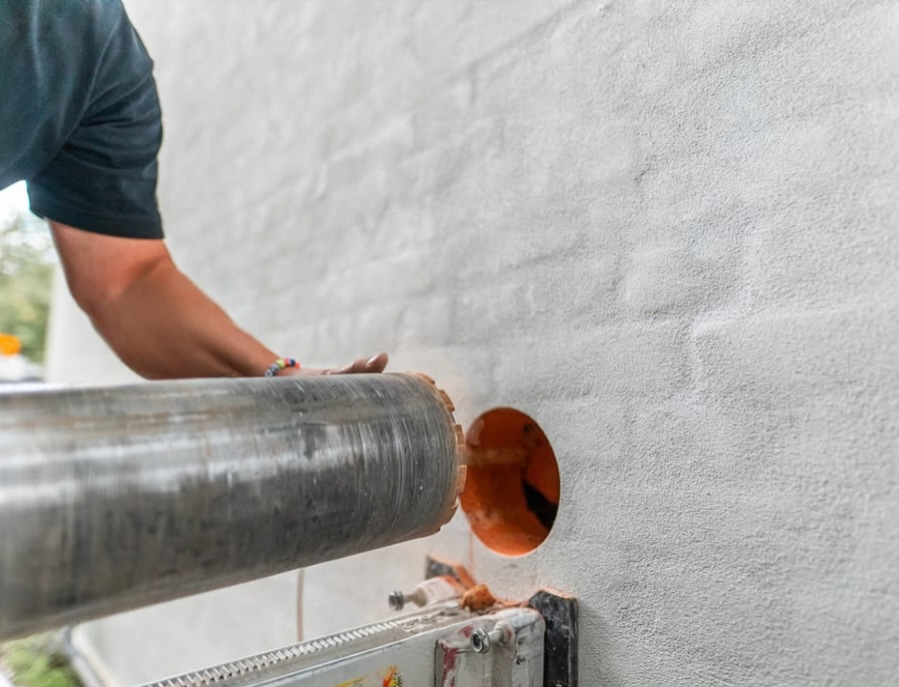 Ett hål borras i betongvägg för att kunna installera Mini-FTX i villa